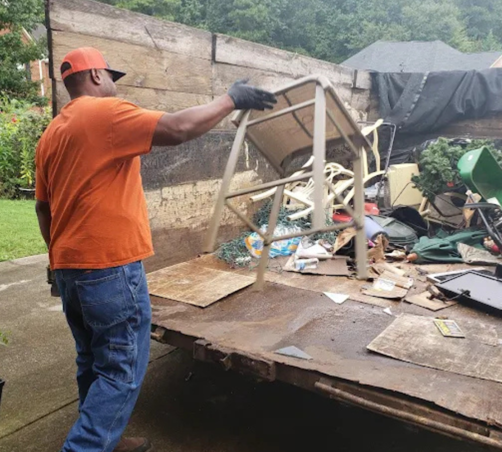 Gogo junk removal technician throwing debris into Gogo junk trailer