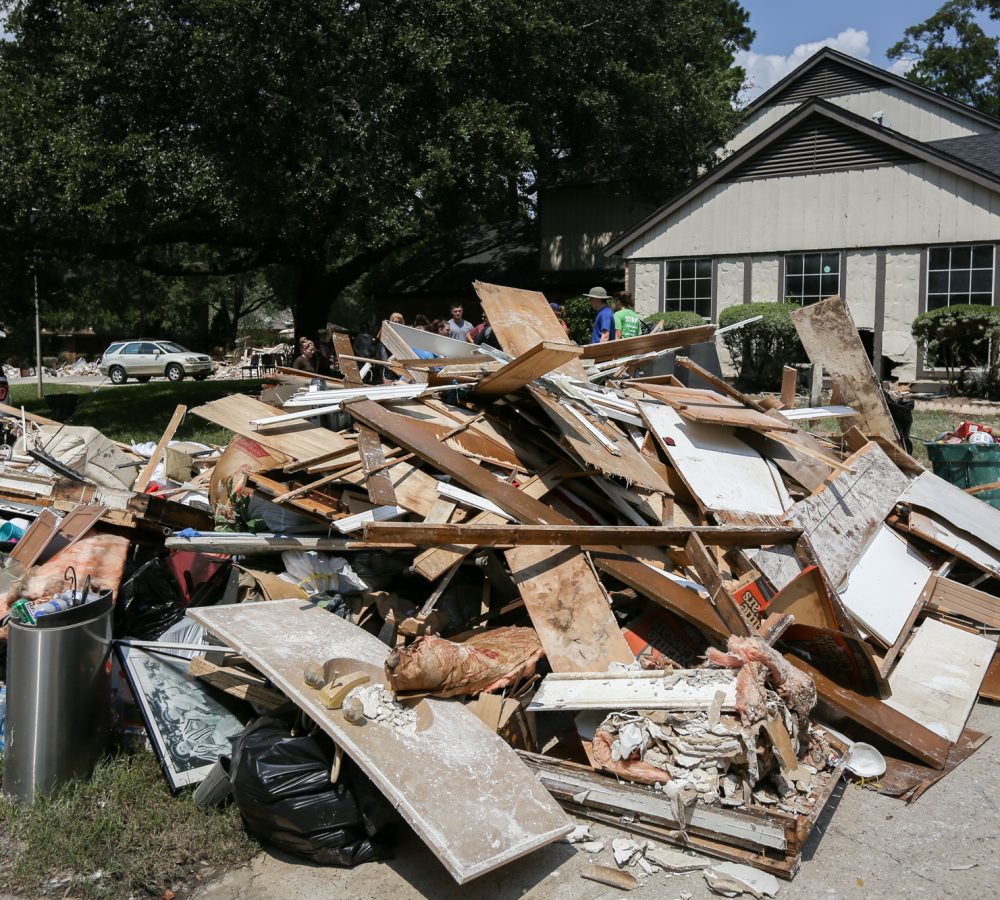 Construction debris from an internal house demolition piled on the front lawn, ready for GoGo Junk Removal pickup.